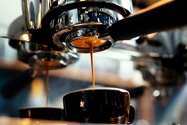 Close-up of espresso pouring from coffee machine.